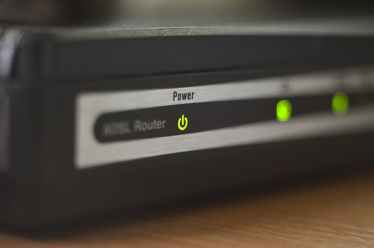 Internet Router - Computer Headquarters Close-up of powered ADSL internet router with glowing LED indicators showing active network connection.