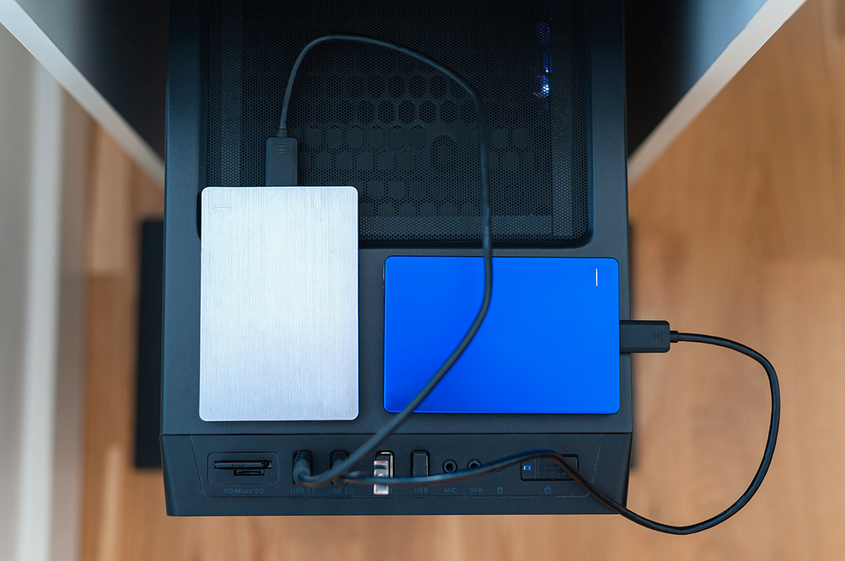 Two external hard drives connected to the back of a desktop computer, representing data storage and backup solutions.