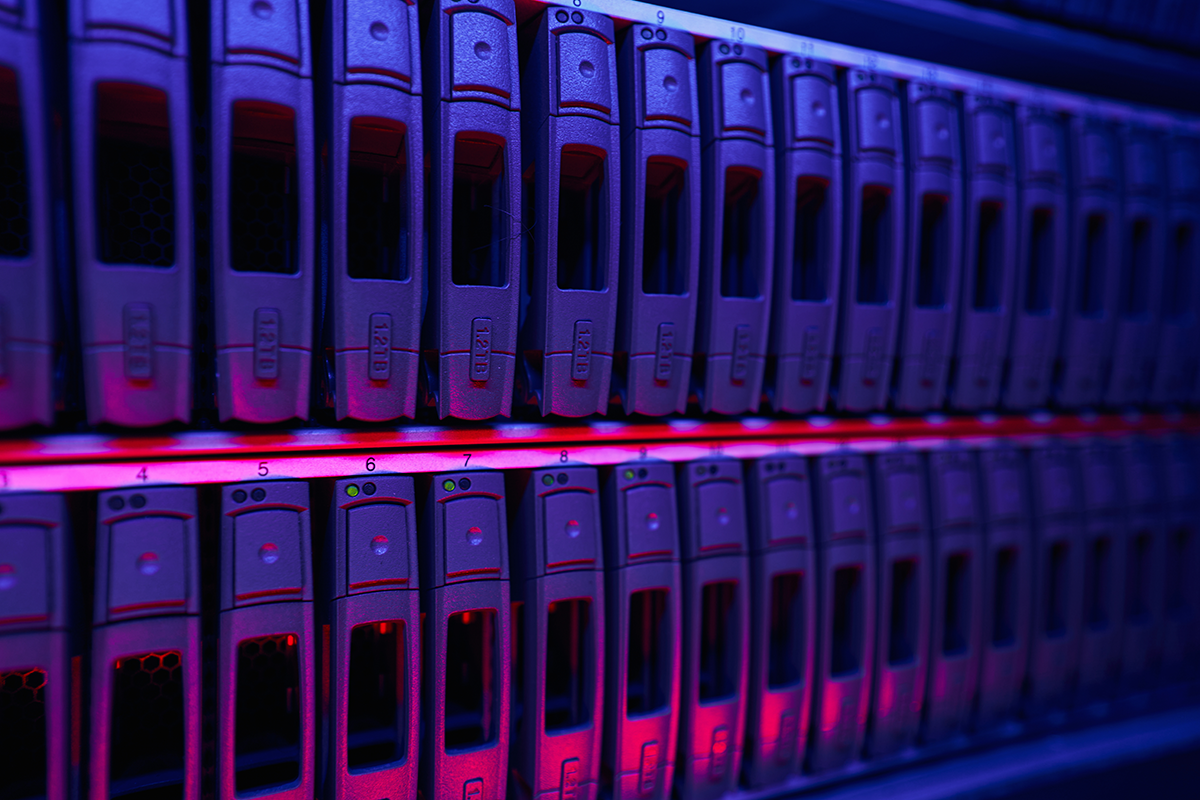 Row of data center storage servers with illuminated panels, representing secure data storage and IT infrastructure.
