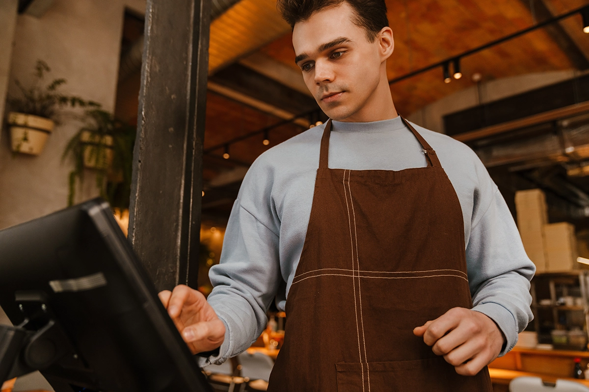 Barista or cashier using a point-of-sale system to process customer transactions